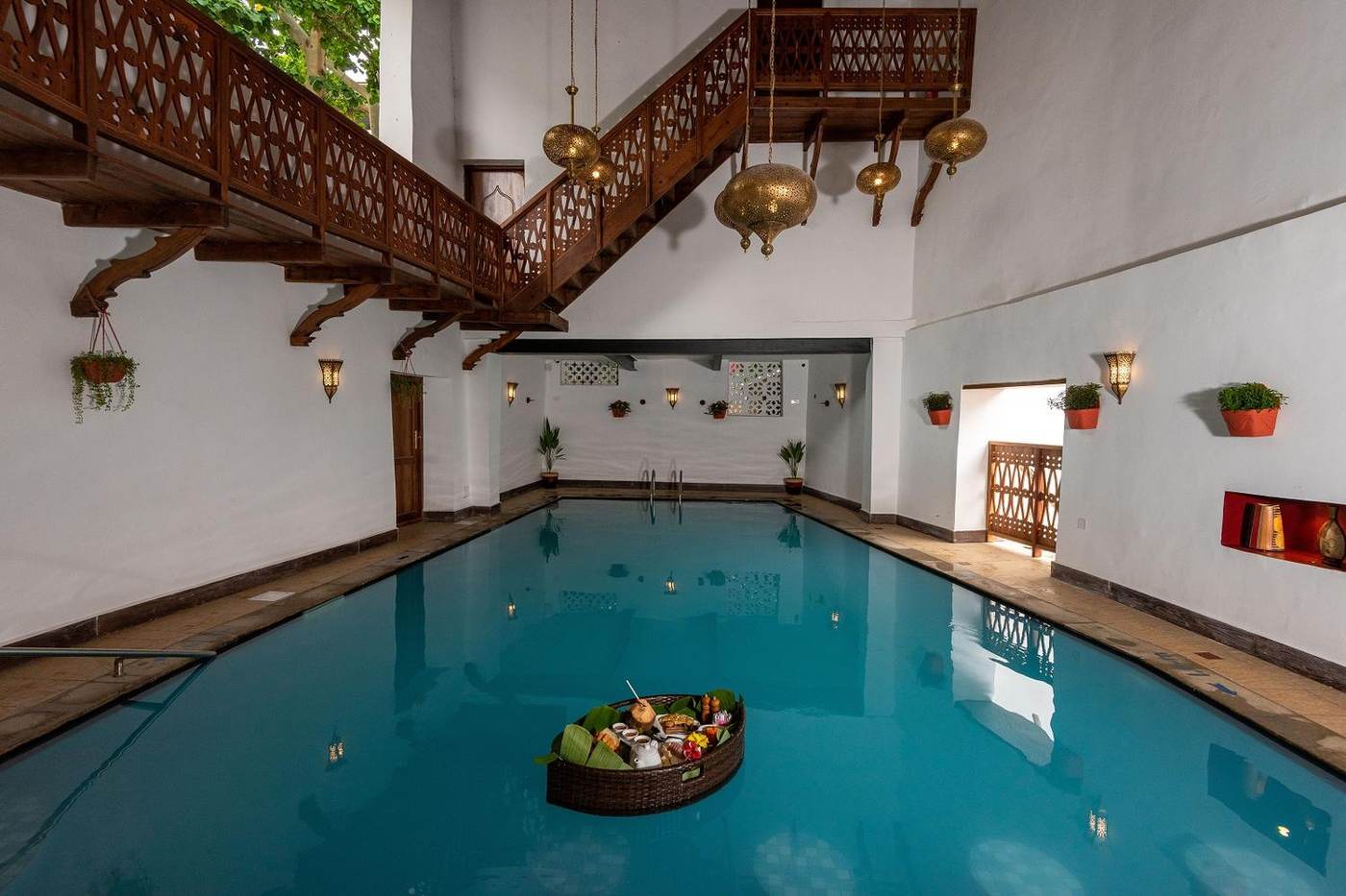 The candlelit central courtyard with carved teak balustrades and brass lanterns